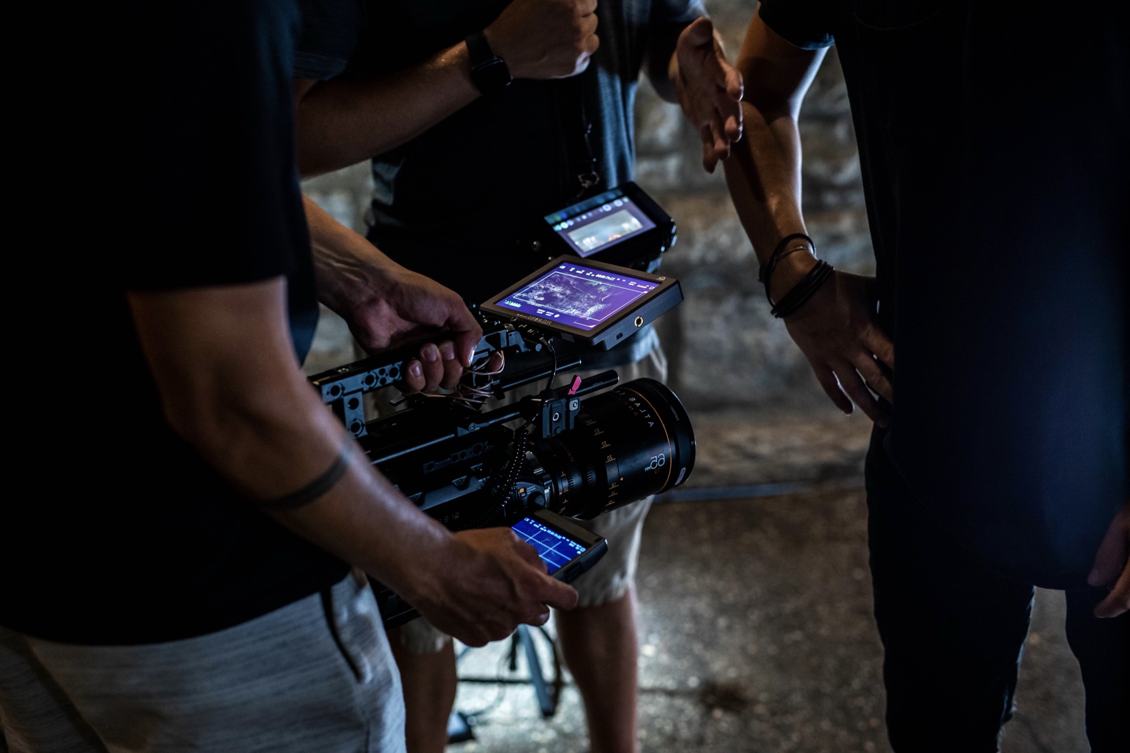 Cinema camera monitors glowing during a low-light production.