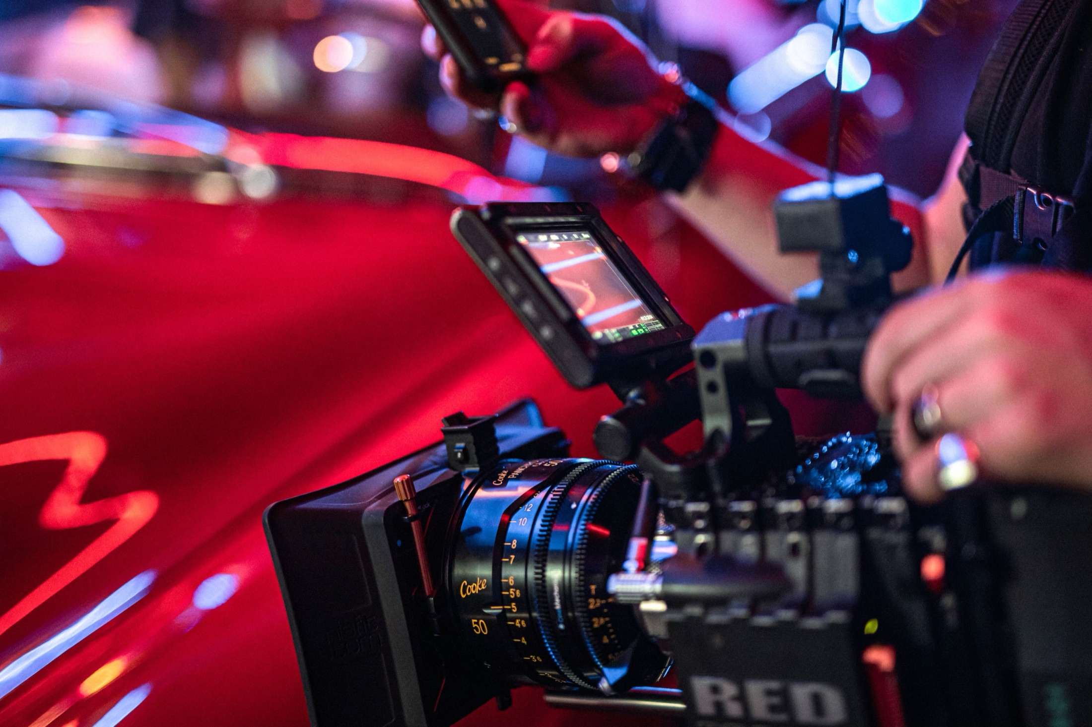 RED cinema camera and Cooke lens beside a car on a night set.